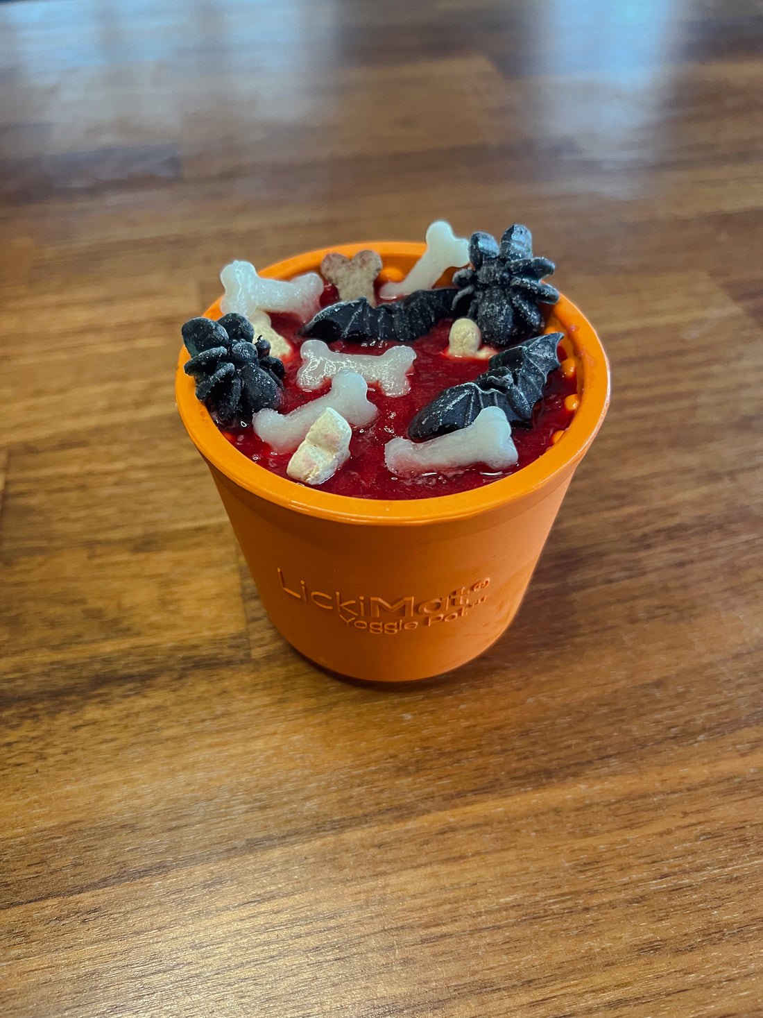 Oranje Halloween YoggiePot met vers vlees, kwark, bietensap, hondensnoep en bevroren hondensnacks.